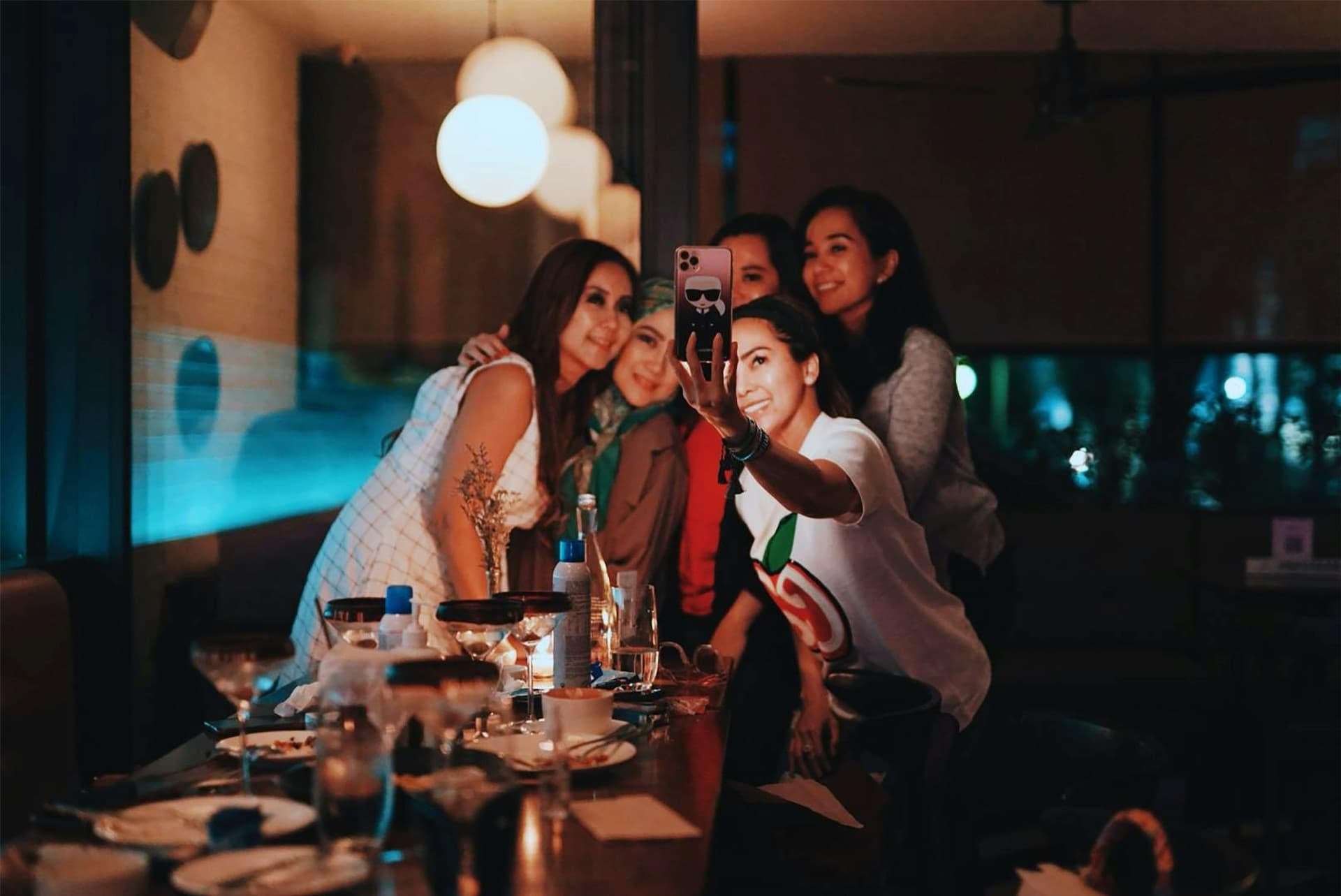 A group of friends taking a selfie together at a dimly lit restaurant