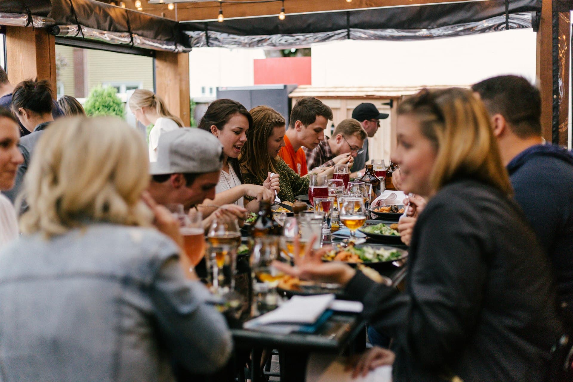 Friends laughing and sharing plates of food around a restaurant table